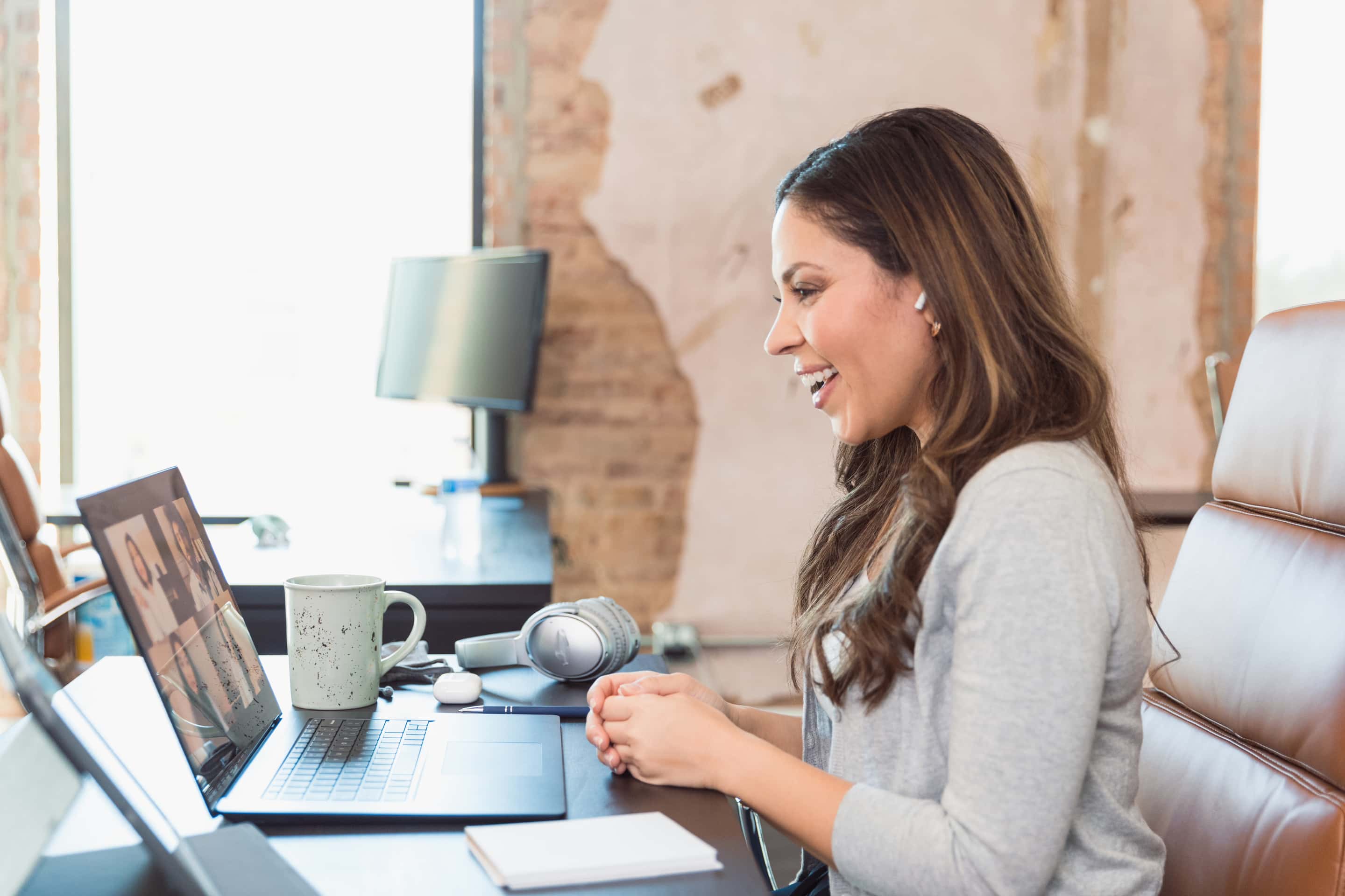 Happy Businesswoman Laughs With Colleagues During Video Conference